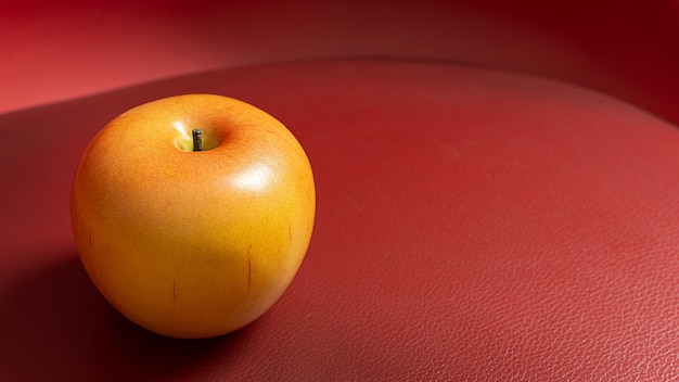 Apple en mesa roja con poca luz para el contenido de alimentos.