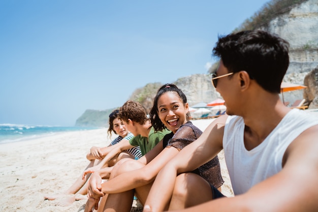 Aprecie a praia com os amigos sentados na areia