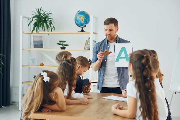 Aprenda uma nova carta Um grupo de alunos em sala de aula na escola com professor