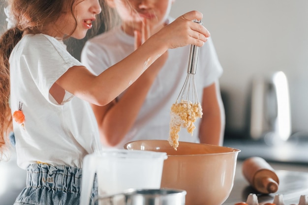 Foto aprendendo a cozinhar menino e menina preparando biscoitos de natal na cozinha