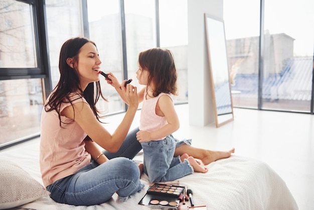 Aprendendo a fazer as pazes Jovem mãe com sua filha passando o fim de semana juntos no quarto