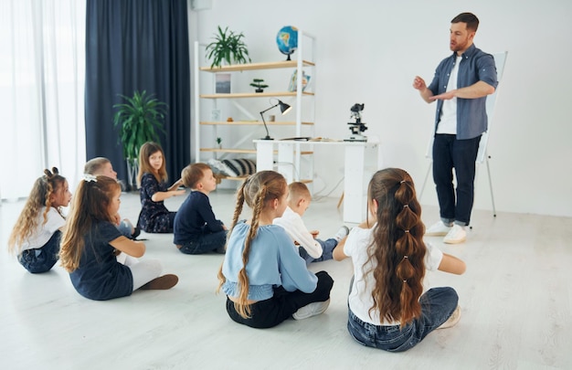 Aprendendo a linguagem gestual Grupo de alunos de crianças em sala de aula na escola com professor