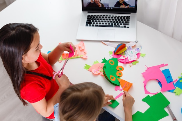 Aprendendo em casa, o conceito de criança de escola em casa. As crianças pequenas estudam a aprendizagem online em casa com um laptop. Quarentena e conceito de distanciamento social.