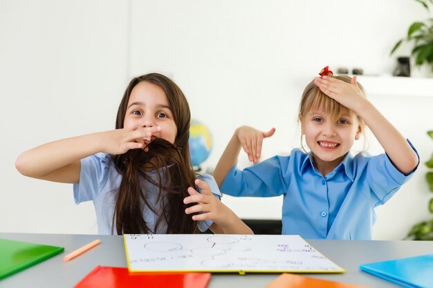 Aprendendo em casa, o conceito de criança de escola em casa. As crianças pequenas estudam a aprendizagem online em casa com um laptop. Quarentena e conceito de distanciamento social.