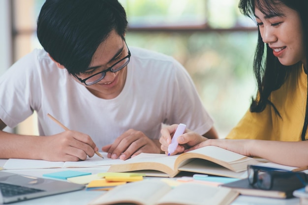 Aprendendo o conceito de educação e escola Jovem mulher e homem estudando para um teste ou exame Livros de tutor com amigos O campus de jovens estudantes ajuda o amigo a se atualizar e aprender