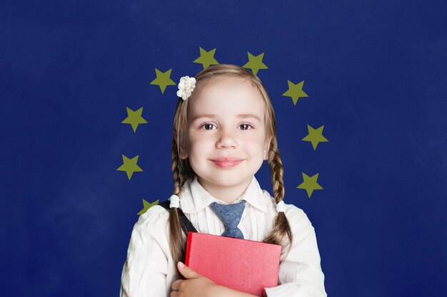 Foto aprender una lengua europea niña inteligente sobre el fondo de la bandera de la ue