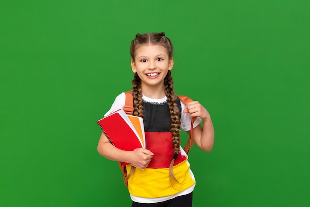 Aprendiendo alemán una colegiala con un libro de texto y una imagen de la bandera alemana en una camiseta