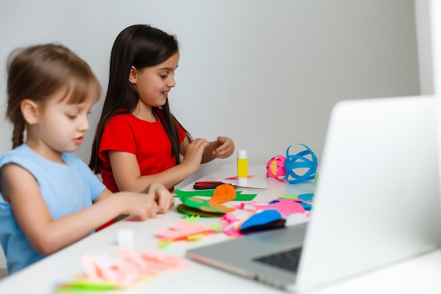 Aprendiendo desde casa, concepto de niño de escuela en casa. Los niños pequeños estudian el aprendizaje en línea desde casa con una computadora portátil. Concepto de cuarentena y distanciamiento social.