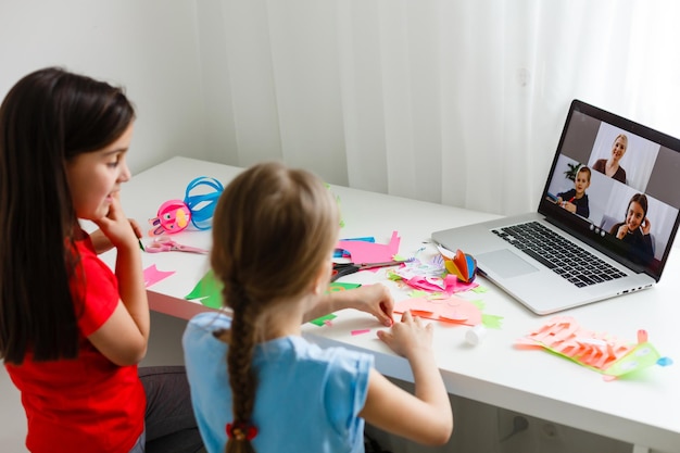 Aprendiendo desde casa, concepto de niño de escuela en casa. Los niños pequeños estudian el aprendizaje en línea desde casa con una computadora portátil. Concepto de cuarentena y distanciamiento social.