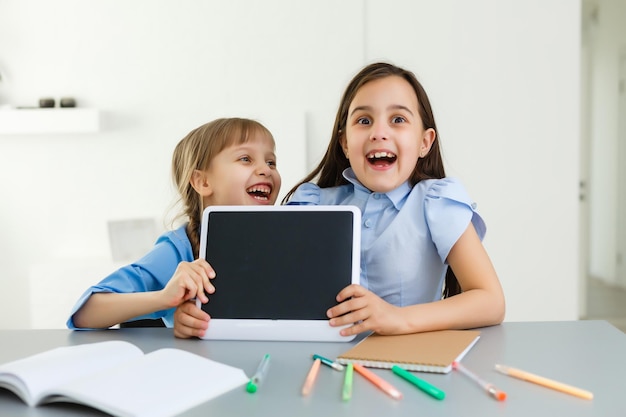 Aprendiendo desde casa, concepto de niño de escuela en casa. Los niños pequeños estudian el aprendizaje en línea desde casa con una computadora portátil. Concepto de cuarentena y distanciamiento social.