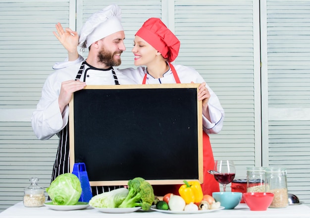 Aprendiendo con expertos culinarios Chef y ayudante de cocina gesticulando bien en el tablero en la escuela de cocina Pareja de hombre y mujer enseñando clase de cocina Cocinero maestro y cocinero de preparación dando espacio de copia de clase magistral