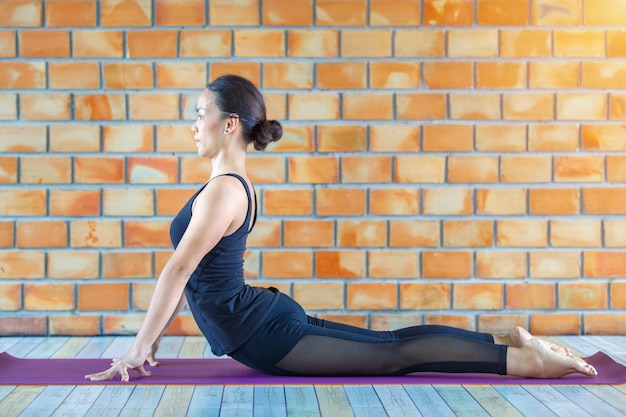 Aprendiz asiática mujer fuerte practicando yoga difícil plantear