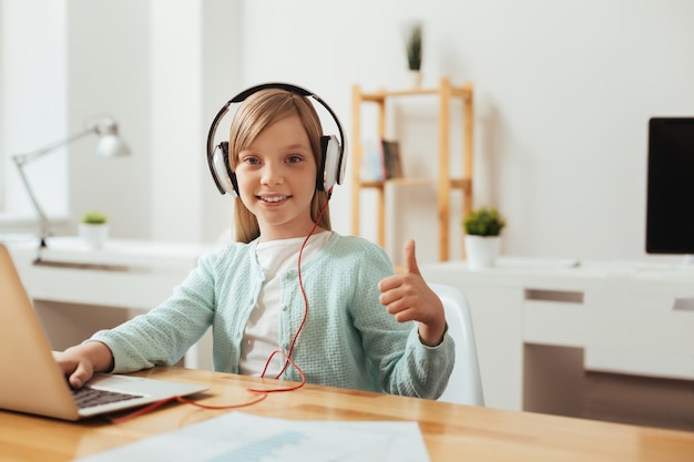 Aprendiz entusiasta. Niño dedicado atento metodológico sentado en la mesa