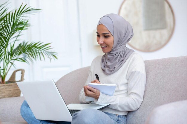 Aprendizagem à distância jovem latino-americana em hijab estudante estudando on-line, ele se senta em casa no