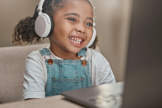 Aprendizagem educacional e laptop com menina e fones de ouvido para conhecimento de videochamada e ensino em casa Cursos on-line em sala de aula virtual e remotos com aluno infantil ouvindo professor para aula