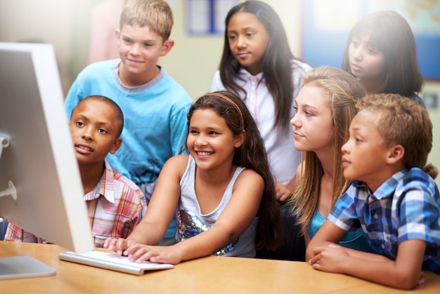 Aprendizagem online colaborativa Um grupo de alunos trabalhando em um computador em sala de aula