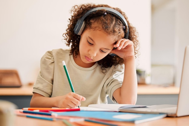 Foto aprendizagem virtual de estudante de escola inteligente enquanto escrevia em seu livro dentro de uma sala de aula de educação criativa com fones de ouvido desenhando arte em papel criança artística bonita fazendo lição de casa