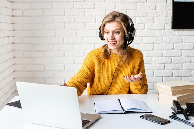 Aprendizaje a distancia e-aprendizaje joven con auriculares negros estudiando en línea usando portátil