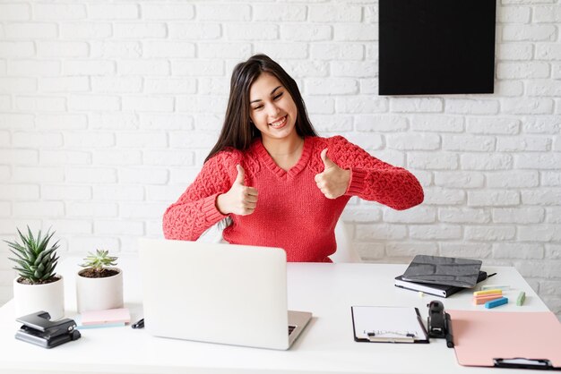 Foto aprendizaje a distancia e-aprendizaje mujer enseñando inglés en línea usando portátil mostrando los pulgares hacia arriba