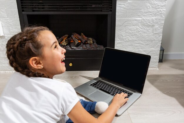 Aprendizaje a distancia para niños. Niña linda que usa la computadora portátil en casa. Educación, estudio en línea, estudio en casa, tecnología, ciencia, futuro, aprendizaje a distancia, tarea, concepto de estilo de vida de los niños de colegiala.