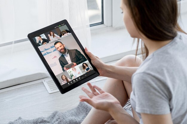 Aprendizaje en línea Clase de seminario web Educación remota Estudiantes relajadas viendo una presentación virtual de entrenador de negocios masculino en la pantalla de la tableta en casa