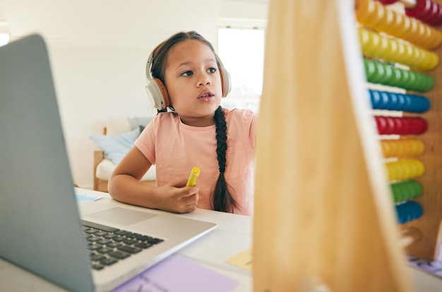 Aprendizaje en línea para niños y ábaco con computadora portátil y aplicación de educación para niños con estudio Computadora joven y auriculares con tecnología y curso digital con niños y aprendizaje electrónico en casa en el escritorio