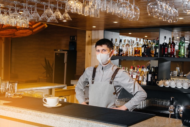 Apresentação de um Barista em uma máscara de delicioso café orgânico em um café moderno durante a pandemia.