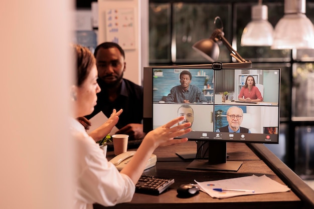 Apresentação do relatório de discussão da equipe corporativa na reunião de videochamada, mulher participando de videoconferência online no computador, conversando com colegas. Comunicação de teleconferência de colegas de trabalho