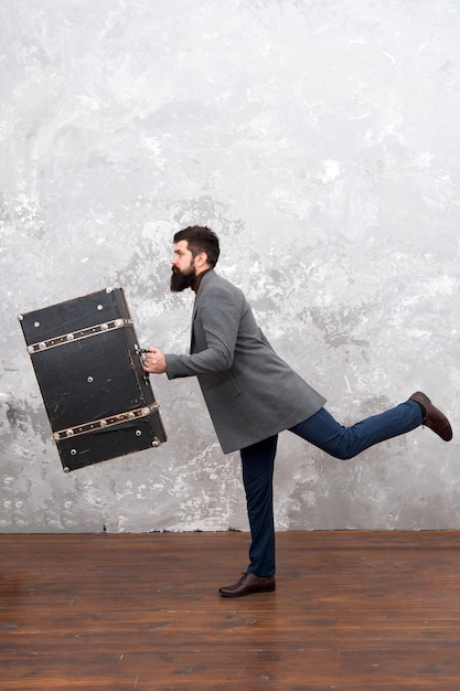 Apresurándose a trabajar. Apresurándose por ser el primero. hombre barbudo con traje listo para el viaje. Apresurándose a nuevas metas. hombre con ropa formal sostiene una bolsa corriendo. Apresurarse para hacer las cosas. Sabe que el tiempo es dinero.