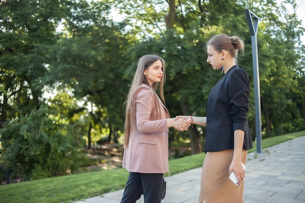 Apretón de manos de dos mujeres de negocios al aire libre