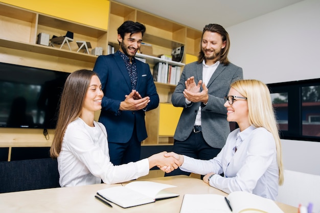 Apretón de manos de mujeres de negocios después de acuerdo de trato