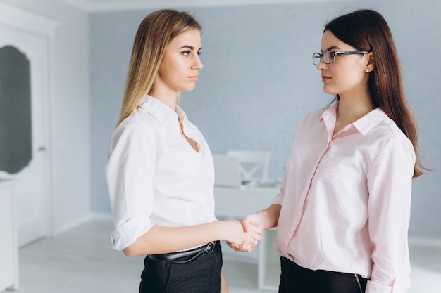 Apretón de manos de las mujeres en la oficina