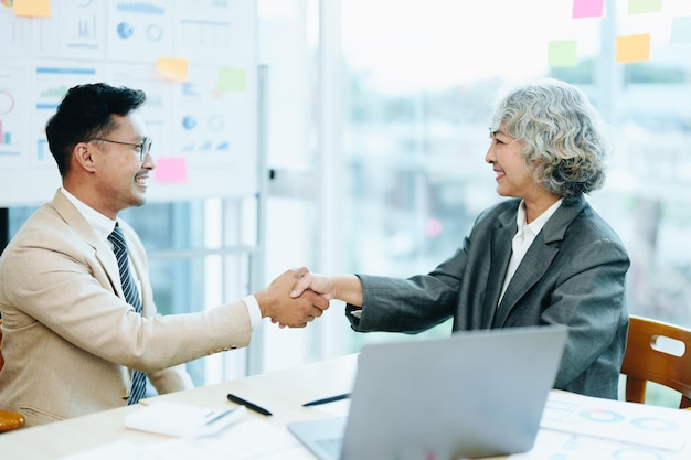 Apretones de manos de empresarios asiáticos para felicitar el acuerdo entre las dos empresas para mejorar la inversión y el concepto de acuerdo de solidez financiera