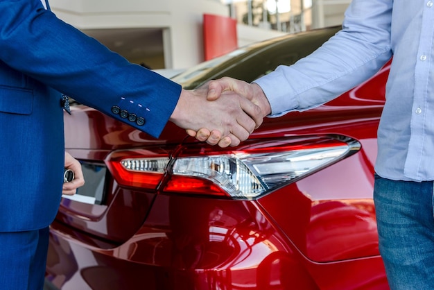 Apretones de manos sobre trato de compra de coche de cerca