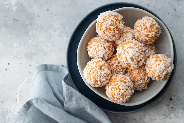 Aprikosen-Kokos-Glückskugeln in blauer Schüssel gesundes rohes veganes Dessert