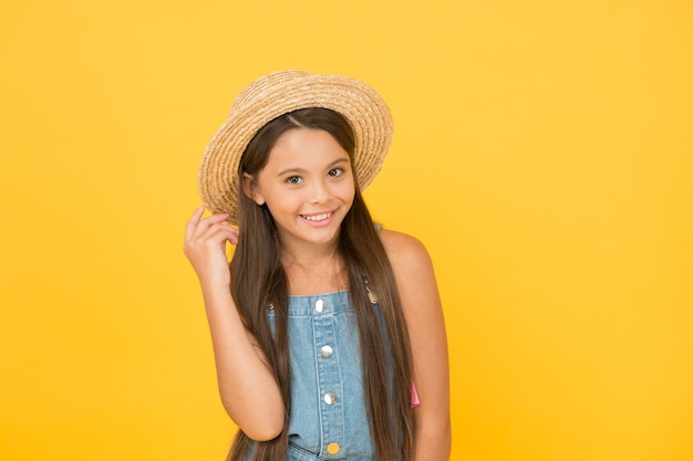 Aproveitando as férias Boas vibrações Estilo de praia Pouca beleza no chapéu de palha Retrato de menina alegre feliz no chapéu de verão fundo amarelo Roupa extravagante Moda de verão de menina adolescente Férias de verão