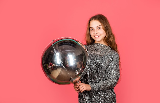 Aproveitando momentos felizes. Menina divirta-se com o balão prateado. Criança feliz brincar com balão de ar. Usando o balão para a festa de aniversário. Balão de festa. Boas festas.