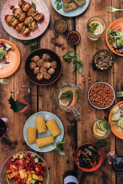 Foto aproveite seu jantar! vista superior de comidas e bebidas na mesa de madeira rústica