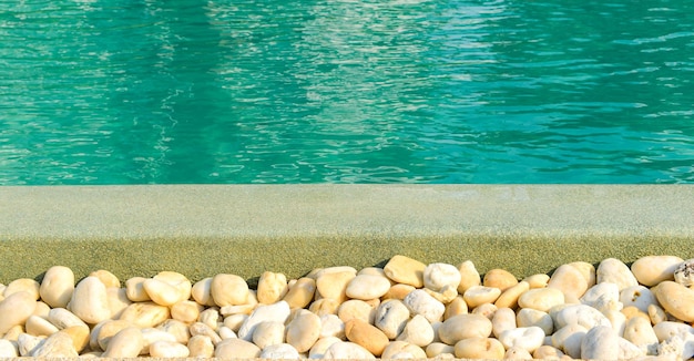 Aproximação da borda de pedra em frente à piscina azul brilhante Decoração e design de piscinas com reflexão da luz solar férias relaxar fuga conceptxA