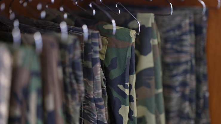 Foto aproximação da coleção de calças de uniforme militar em roupas militares de camuflagem de guarda-roupa