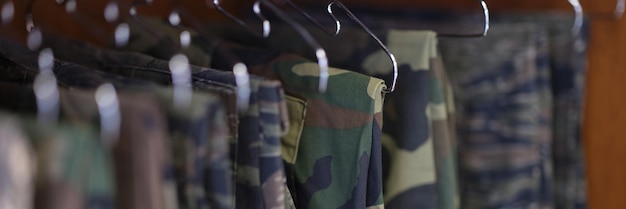 Aproximação da coleção de calças de uniforme militar em roupas militares de camuflagem de guarda-roupa