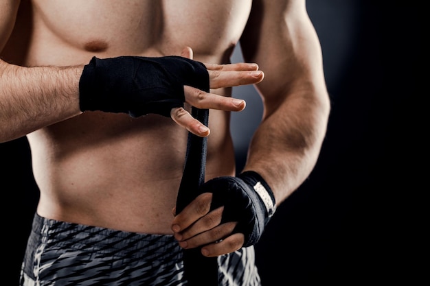 Aproximação da mão de um boxeador masculino com bandagens de boxe Punhos de um lutador antes de uma luta ou treinamento