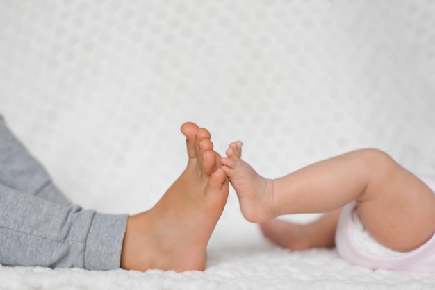 Aproximação das pernas de dois irmãozinhos e irmãs tocando um ao outro Filho de relações familiares