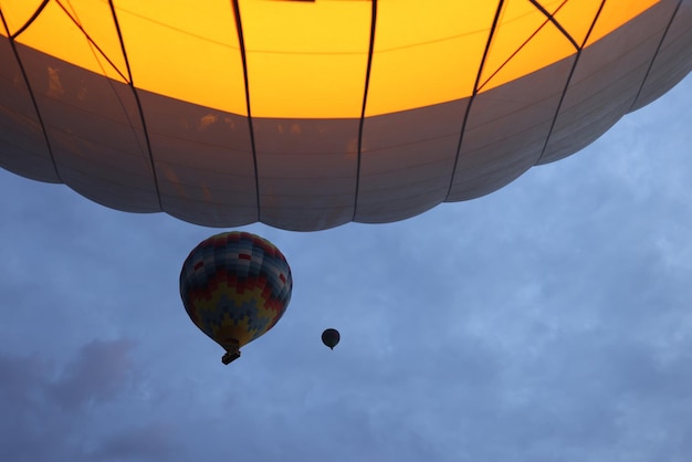 Aproximação de balões de ar coloridos quentes na atividade turística popular de fundo do céu noturno