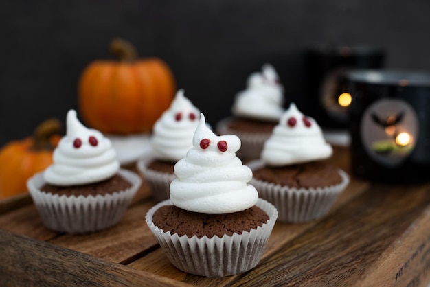 Aproximação de cupcakes fantasmas assustadores para o halloween na mesa com fundo embaçado