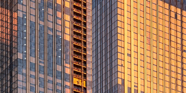 Aproximação de edifícios de escritórios modernos amanhece o pôr do sol com nuvens refletidas nas janelas