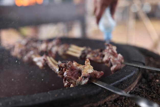 Aproximação de espetos de carne em piquenique de churrasco em fogo aberto cozinhando shish kebab churrasco e piquenique