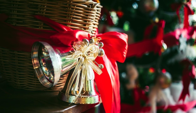 Aproximação de sinos gêmeos e fita vermelha adornando a cesta no fundo de Natal do dia de Natal