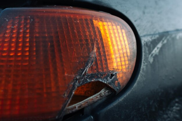 Aproximação de um farol de carro quebrado com vestígios de reparo Foco seletivo