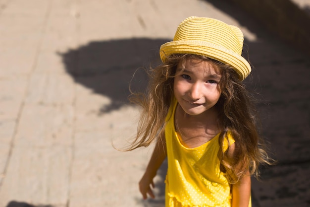 Aproximação de um retrato de verão de uma garota de chapéu amarelo e vestido de verão liberdade de verão ensolarado